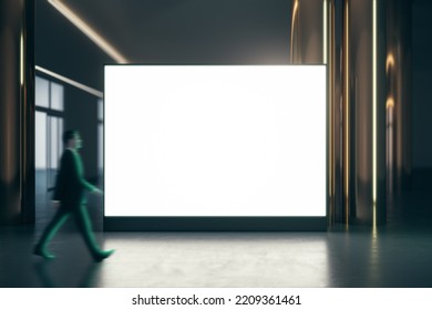 Walking Businessman By Blank White Illuminated Big Screen With Place For Your Logo Or Text Between Golden Pillars With Glossy Floor On Dark Empty Room Background, Mock Up