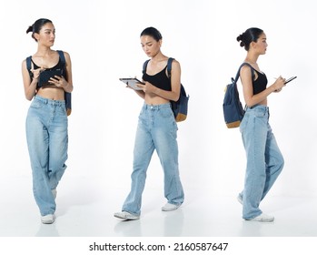 Walking with cell smart phone Full length Figure snap of 20s Asian Woman black hair vast jeans pant and sneaker. Casual beautiful Female walk with backpack over white Background isolated