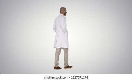 Walking doctor in a robe on gradient background. - Shutterstock ID 1827071174