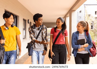 Walking in high school hallway, group of teenagers talking and smiling with backpacks. Students, education, conversation, friendship, high high school, youth - Powered by Shutterstock