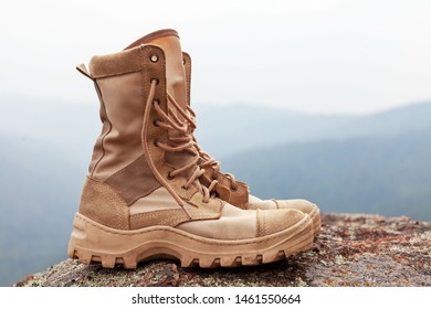 Walking High Yellow Army Boots On Stones, Concept Of Hiking And Adventure Trekking