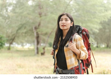 Walking Into The Wilderness Is A Lovely Asian Backpacking Woman.