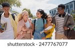 Walking, laughing and students at university with fun for learning, bonding and talking. People, diversity and group of gen z friends outdoor with books ready for education at college campus.