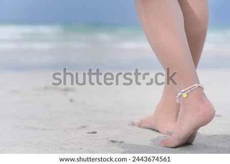 "Walking on the beach" close up of the woman feets waring anklets and walking on the beach 