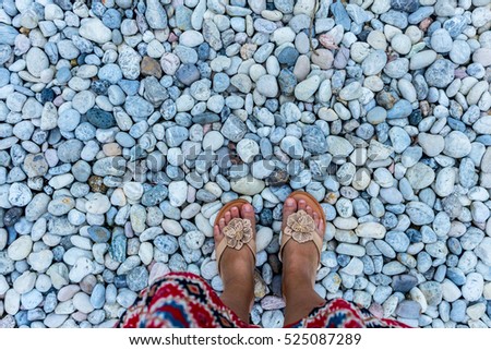 Walking on pebbles close up of female feet