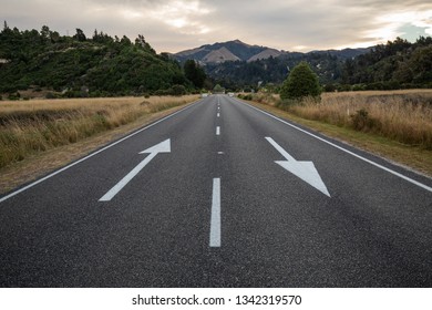 Walking On The Road To Future Life With Two Arrows In Opposite Directions, With A Mountain Representing Success In The Background