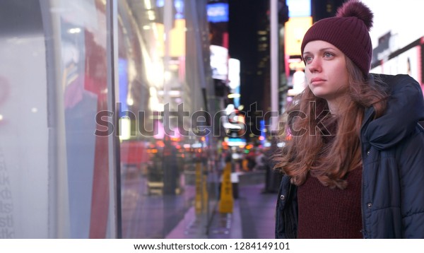 Walking on Times Square New York by night while\
doing a sightseeing trip to\
Manhattan