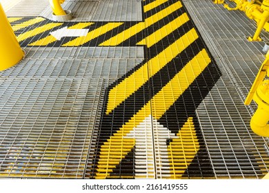 Walking on walkway Metal grating on the Wellhead Platform of Oil  Gas in the offshore with safety sign colors.