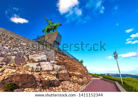 Walking path around the stone monument to Salawat Yulaev in a summer sunny day with blue sky, bottom view in front of the rocks. Salavat Yulayev, Ufa, Bashkortostan, Russia.