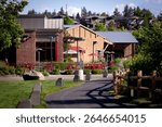 A walking path, a riverside trail at Old Mill District, historic mill buildings turned outdoor retail mall with shops, restaurants and in downtown Bend, Oregon, by Deschutes River