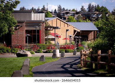 A walking path, a riverside trail at Old Mill District, historic mill buildings turned outdoor retail mall with shops, restaurants and in downtown Bend, Oregon, by Deschutes River