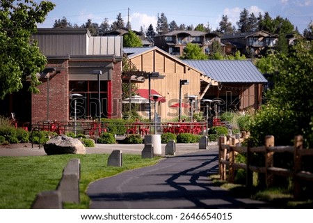 A walking path, a riverside trail at Old Mill District, historic mill buildings turned outdoor retail mall with shops, restaurants and in downtown Bend, Oregon, by Deschutes River