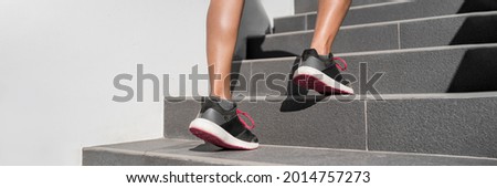 Walking up the stairs leg workout. Hiit training running up staircase. Fitness woman going up steps panorama banner. Runner athlete sport shoes closeup.