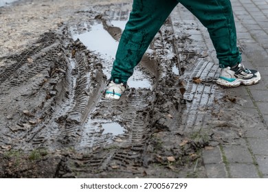 Walking Through Muddy Puddle After Rain — Dirty Sneakers and Tire Tracks Symbolizing Real Life and Imperfection