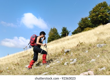 Walking uphill woman trekking and hiking mountaineering