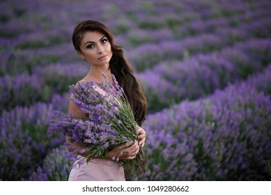 Walking women in the field of lavender.Romantic women in lavender fields. Girl admires the sunset in lavender fields