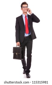 Walking Young Business Man With Briefcase , Looking Away From The Camera While Speking On His Smartphone, Isolated On White Background