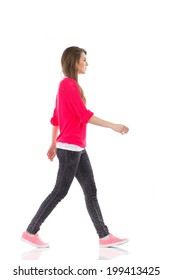 Walking young woman, side view. Full length studio shot isolated on white.