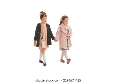 Walks. Studio Shot Of Little Happy Girls In Retro Style Autumn Outfit, Fashion Of 70s, 80s Years Isolated On White Background. Concept Of Emotions, Facial Expression, Beauty. Copy Space For Ad