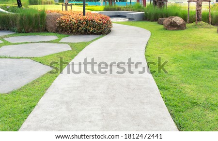 Walkway and bush. That is concrete pavement, floor, passage, path, footpath, pathway or passageway with nature for walking along and connecting different section of a building, park or garden.