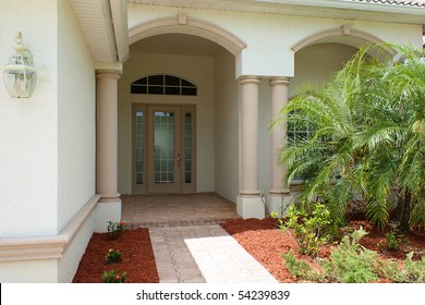 Walkway And Front Door To Generic High End Home In Southwest Florida With Small Palm Tress.