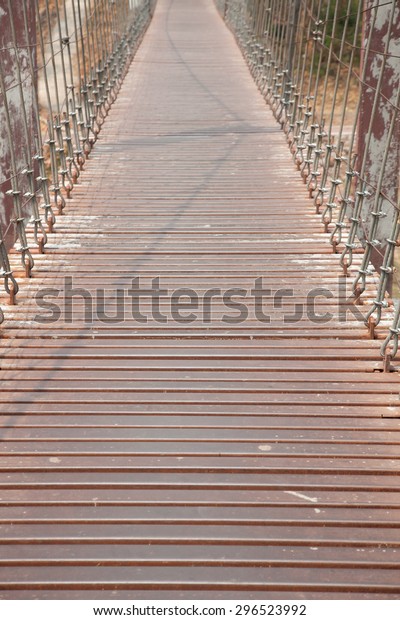 Walkway on the bridge. The metal rod attached to a\
rope bridge across the\
river.
