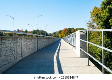 Walkway On A Bridge Over Credit River Ontario With Colorful Fall Foliage Surrounding It