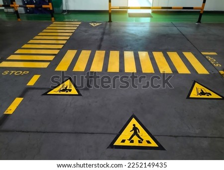 Walkway signs and painted yellow on the factory floor. Signs for safe passage at industrial plants