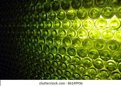 Wall of back-lit green bottles