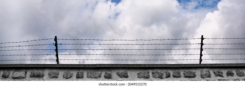 Wall and barbwire, blue sky background