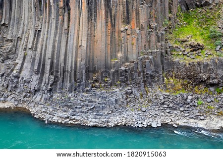 The wall of basalt columns in Studlagil canyon in Jokuldalur Valley in Iceland. Texture of a volcanic basalt rock. 