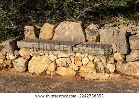 Wall and bench made with the dry stone technique, marge, in a ruinous and abandoned state. Island of Mallorca, Spain Stockfoto © 