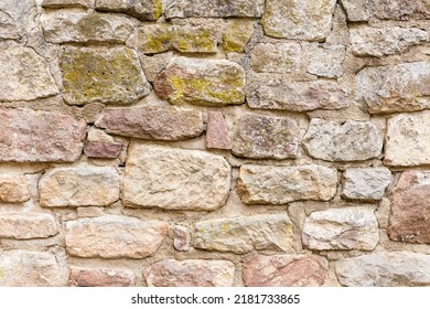 Wall Or Brick Wall Made Of Sandstone Bricks With Cracked Grout And Moss