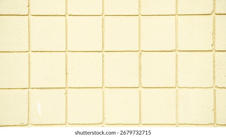 The wall is built of square bricks, rough and plastered, painted light yellow.