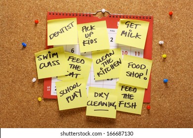 Ein Wandkalender auf einem Korkbrett mit gelben klebrigen Papiertafeln als Erinnerung an die Hausarbeit und die zu erledigenden Aufgaben. Ein Konzept für Multitasking