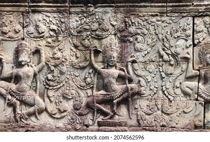 Wall carving with two womans dancers apsara, famous Angkor Wat complex, Siem Reap, Cambodia. Horizontal background with stone texture and bas-relief with dancing girls