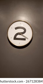 Wall clock with a large number two design and simple black hands on a plain background