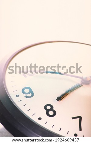 Wall clock on a light wall background. Cover. For design. Slide. Photographic film.