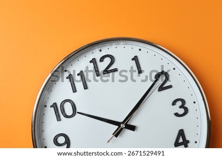 wall clock on orange background
