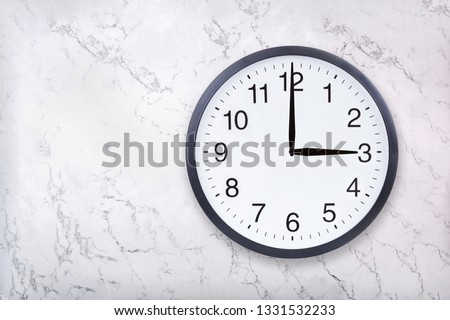 Wall clock show three o'clock on white marble texture. Office clock show 3pm or 3am on marble background