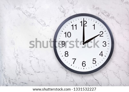 Wall clock show two o'clock on white marble texture. Office clock show 2pm or 2am on marble background
