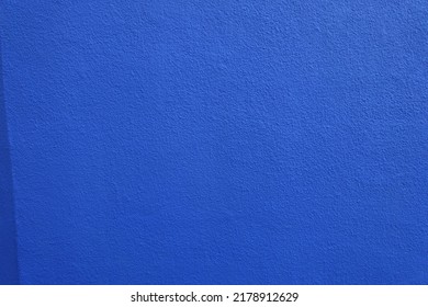 wall with coarse vibrant blue roughcast finish (front view)