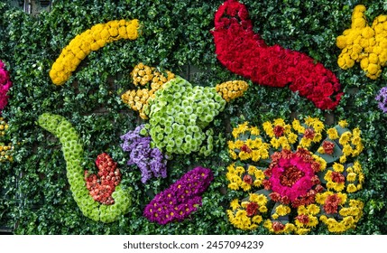 A wall covered in flowers and plants with a green background. The flowers are in various colors and shapes, creating a vibrant and lively atmosphere. The arrangement of the flowers - Powered by Shutterstock