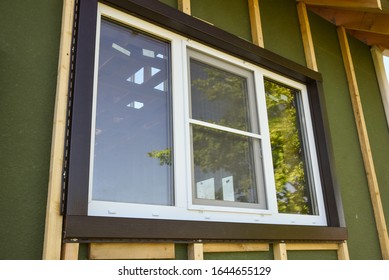 Wall Covering Of The Frame House With Panels Of Vinyl Siding. Construction Or Reconstruction, Repair Of The House. Installation Of Plastic Windows In A New Residential Building.