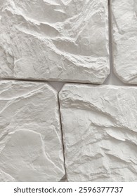 Wall decoration with artificial wild gray stone of arbitrary shape. Finishing works, wall cladding. Close-up.