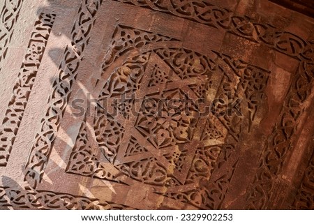 Wall decorative patterns of Qutb complex in South Delhi, India, close up ancient bas relief wall decorations of mosque ruins landmark, popular touristic spot in New Delhi, ancient indian architecture