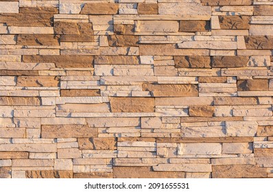 The Wall Is Faced With Brown Stone. Building Stone Texture.