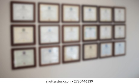 A wall featuring multiple framed certificates and diplomas, likely in an office or professional environment, showcasing achievements and qualifications.