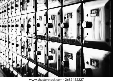 Wall full of rows of old shiny metal post office deposit value boxes	
