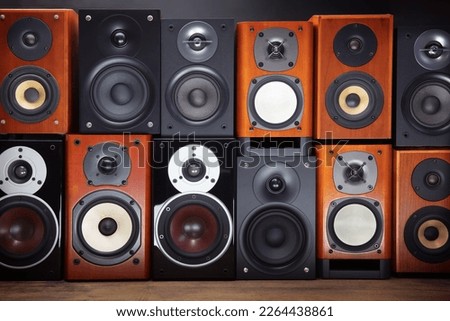 A wall of hi-fi audio speakers. Mid sized audio speakers or monitors stacked up.